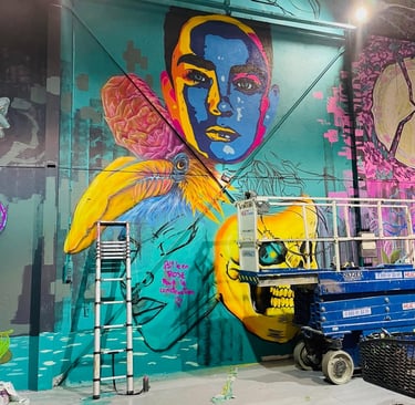 une fresque en cour de création avec une nacelle et une échelle