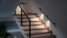 a staircase with lighting on the handrails on the steps