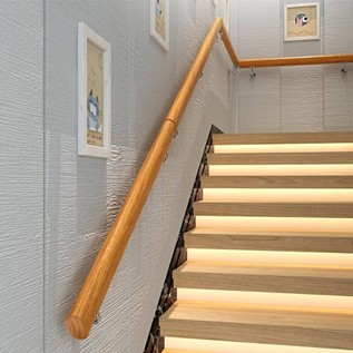 Picture of a stairs with handrails going along the wall and on the vertical incline.