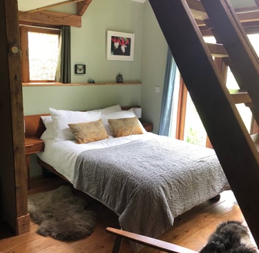 holiday rental interior view under the wooden staircase through to the double bed