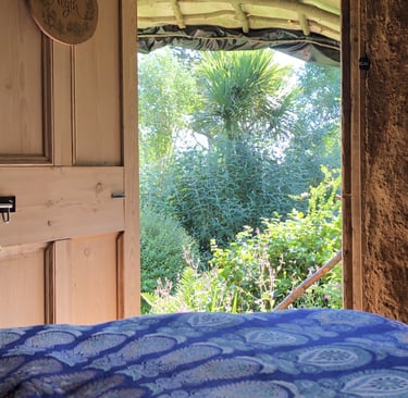 view out from a bedroom to a lush green garden
