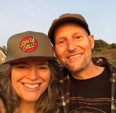 smiling couple wearing hats taken at sunset