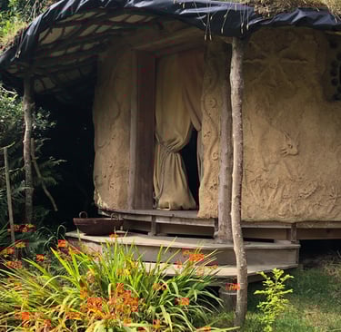 cob round house set in a wild garden