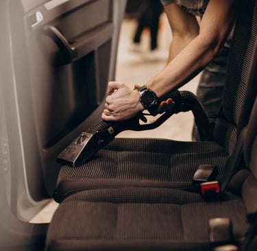 Homme qui nettoie un siège de voiture