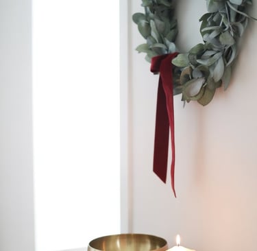 a candle with a candle and a wreath on a table