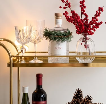 a bar cart with wine bottles and pine cones