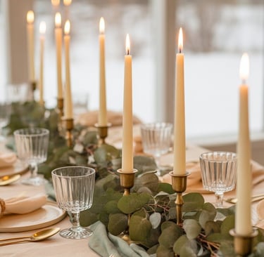 An intimate winter tablescape with candles, greenery, and neutral linens creating a softly glowing,
