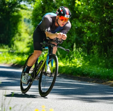 Un triathlète est allongé sur son vélo pour plus d'aérodynamisme