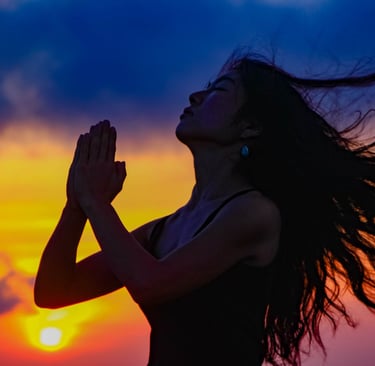 woman praying at sunset