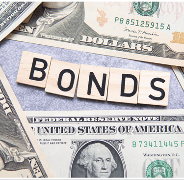 a pile of money with the word bonds spelled in wooden blocks