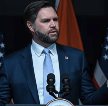 a man in a suit and tie standing at a podium
