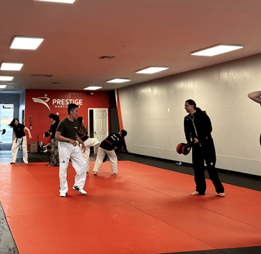 a group of people standing around a man in a karate pose