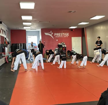 a group of people standing around a man in a karate pose