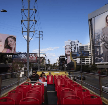 a bus stop with red chairs and billboards