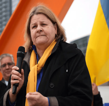 a woman in a black coat and yellow scarf