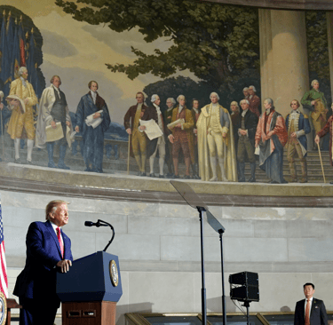 a man in a suit and tie standing at a podium with a microphone