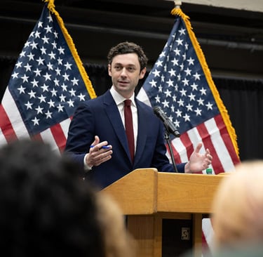 a man in a suit and tie is speaking into a microphone