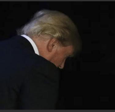 a man in a suit and tie is looking down at the ground