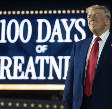 a man in a suit and tie standing in front of a sign that says,