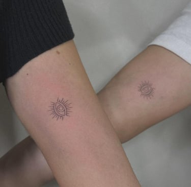 Fine line evil eye sun tattoo on upper arm – Sinkply Zürich