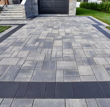 Modern staggered ashlar concrete paver driveway with dark charcoal border at a luxury Sarasota home