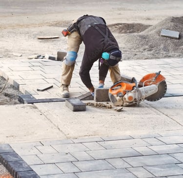 Paver installation crew laying natural stone pavers with precision during a Sarasota outdoor pro