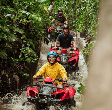 a group of people riding on four - wheelers through a river