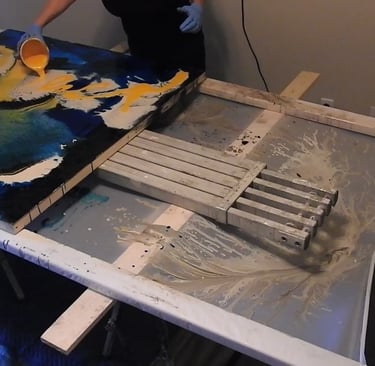 a person is painting a large painting on a table