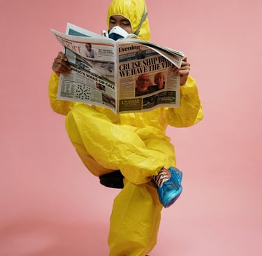 Homme vêtu d'une combinaison de protection jaune et d'un masque à gaz intégral lit un journal