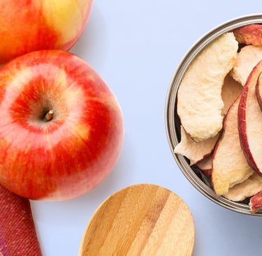 fresh red apple near open can of freeze dried apples