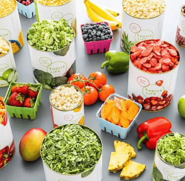 A stockpile of Thrive Freeze dried food cans opened along with fresh food