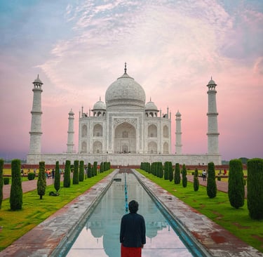 a man standing in front of a building with a fountain