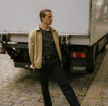 portrait of artist and designer Philipp Schäfer standing on a brick sidewalk next to a truck