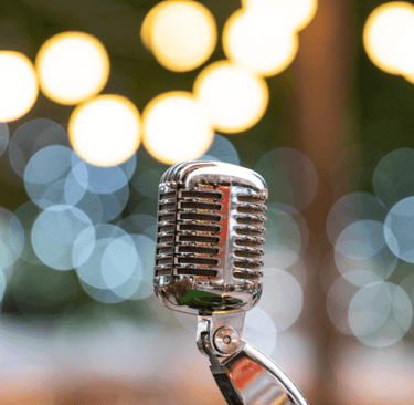 a microphone standing alone with a blurry colourful background