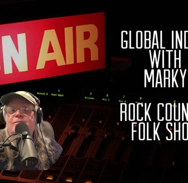 mark glazier (marky)  in a hat and a microphone in front of a radio set