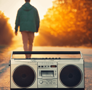 an old fashion boom box and a man walking away towards a sunset