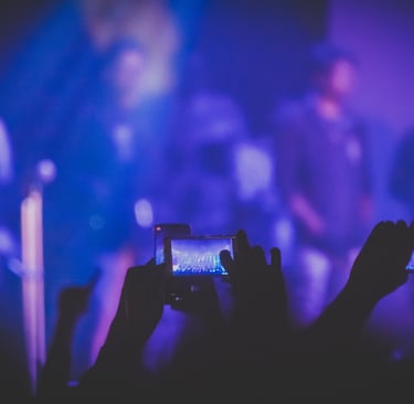 a person holding a cell phone in front of a stage