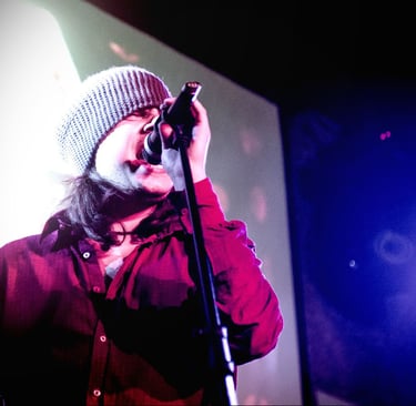 a man in a beanie hat and a microphone