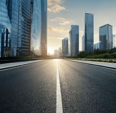 a city street with a road and buildings in the background