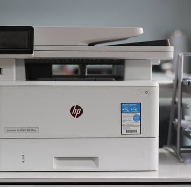 HP LaserJet Pro MFP M427dw wireless monochrome laser printer on a modern office desk.