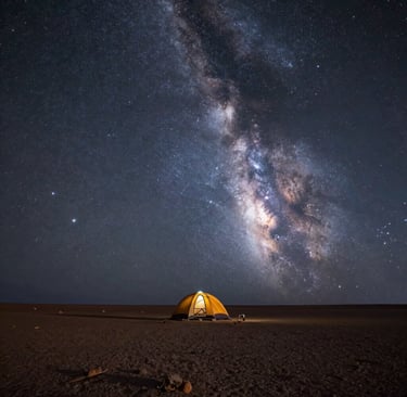 A glowing yellow camping tent under a vibrant Milky Way galaxy night sky in the desert.