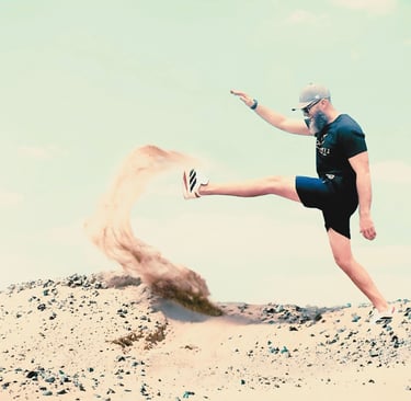 a man with a black shirt is kicking a sand