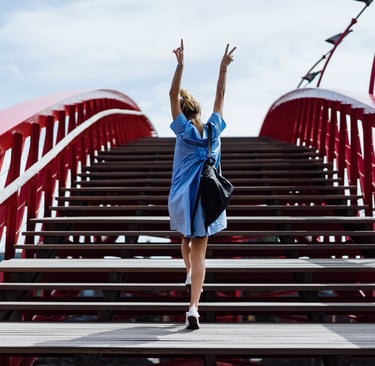 a woman in a blue dress standing on a bridge