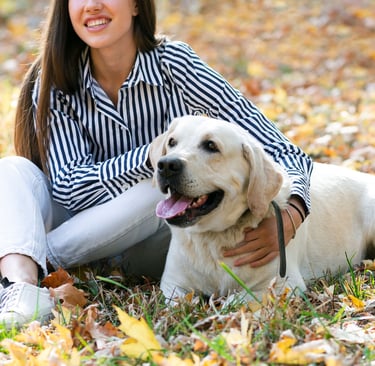a woman sitting on the ground with her dog