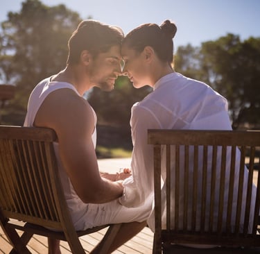 a man and woman sitting on a wooden deck