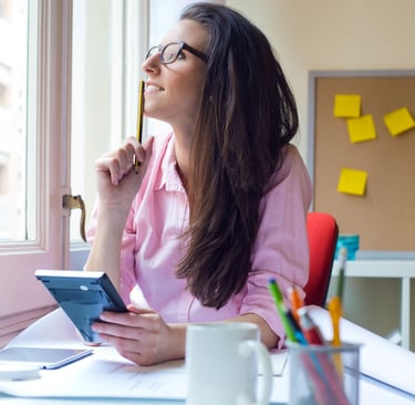 a woman sitting at a desk with a note pad and pen