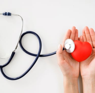 a person holding a red heart in their hands