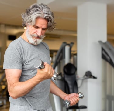 a man in a gray shirt training with dumbbells