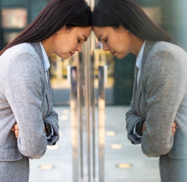 a sad women standing in front of a glass door