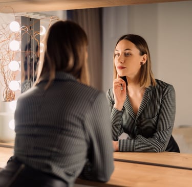 a woman in a business suit is looking at her reflection in the mirror